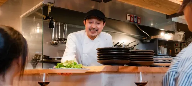 笑顔で料理を提供するシェフ